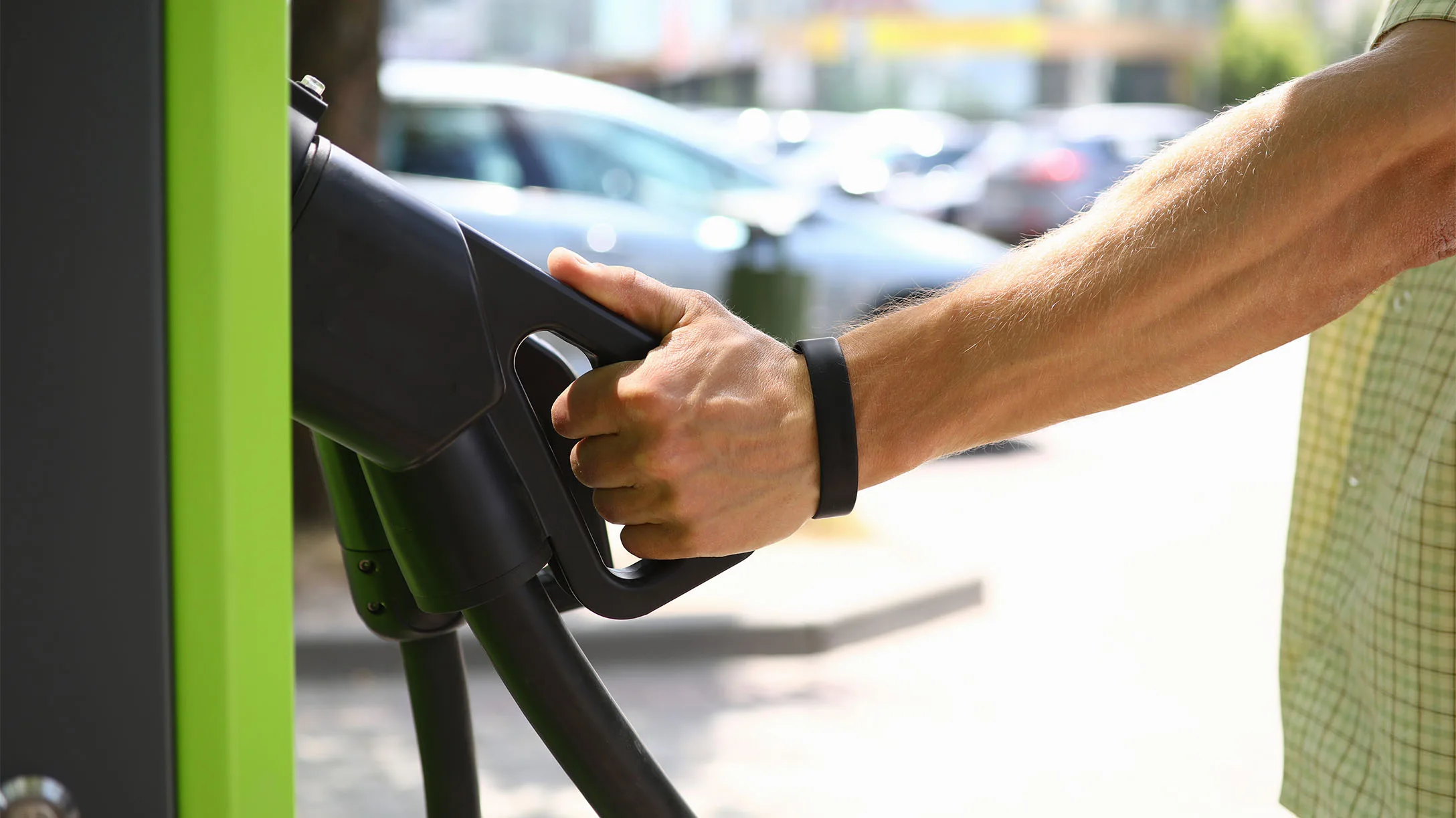 Persona sosteniendo la pistola de carga de bateria de furgon electrico